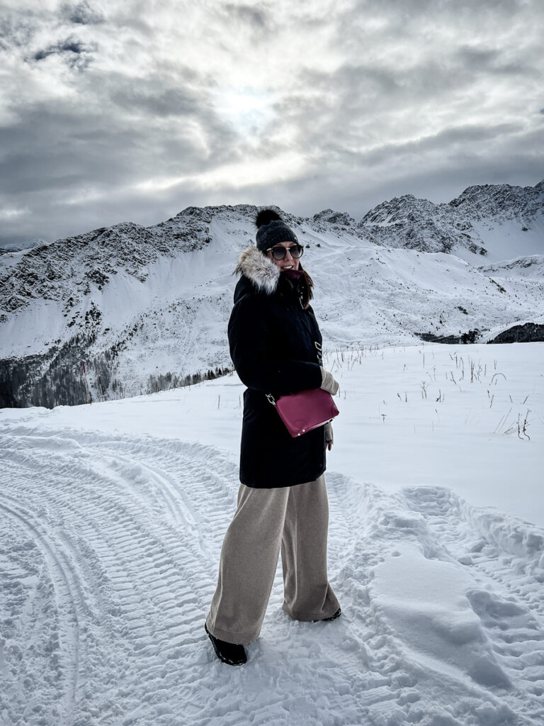 Arosa Switzerland, view of the snowy Swiss Alps on the front of the image is a girl staying on the snowy road.