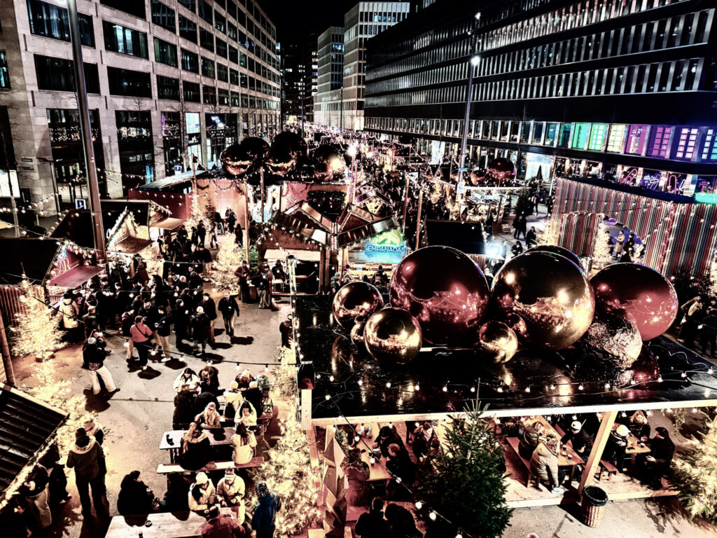 Overhead view of Zurich’s Weihnachtsallee Christmas Market with illuminated trees, food stalls, and festive decorations.
